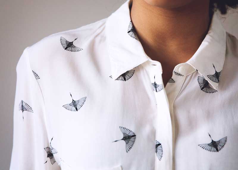 What to wear for a professional headshot. White shirt collar with black bird print.